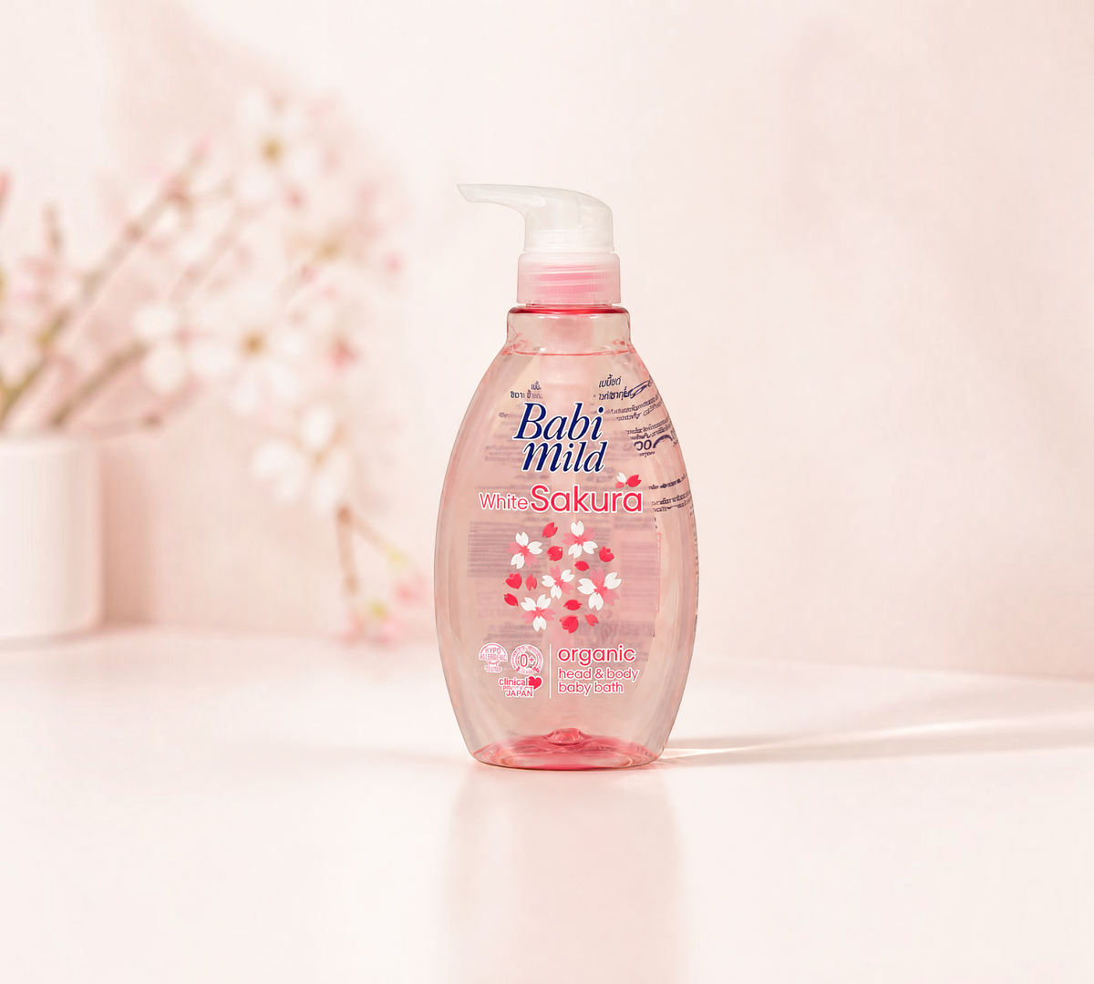 Thai Ranee Babi Mild White Sakura organic head and body baby bath in a 380ml pump bottle with floral background.