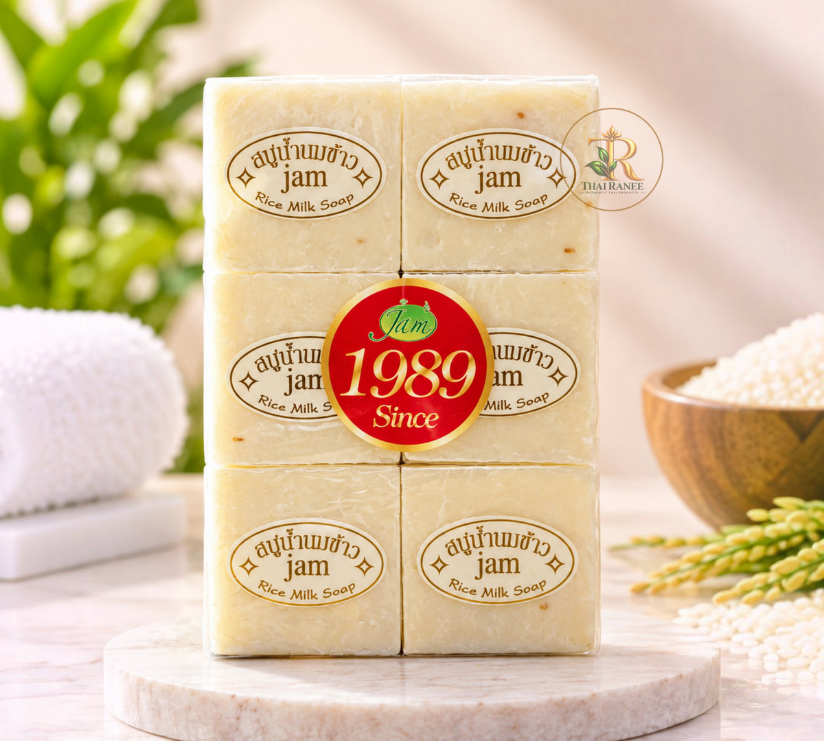 Thai Ranee Jam natural handmade rice milk soap bars with collagen and gluta in clear packaging on a marble surface.