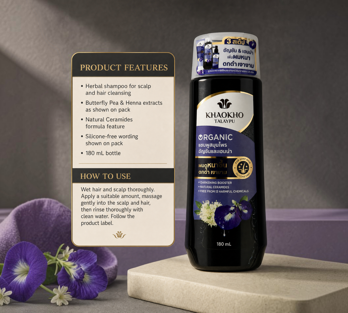 Thai Ranee Khaokho Talaypu organic butterfly pea and henna shampoo bottle for gray hair on a stone pedestal.
