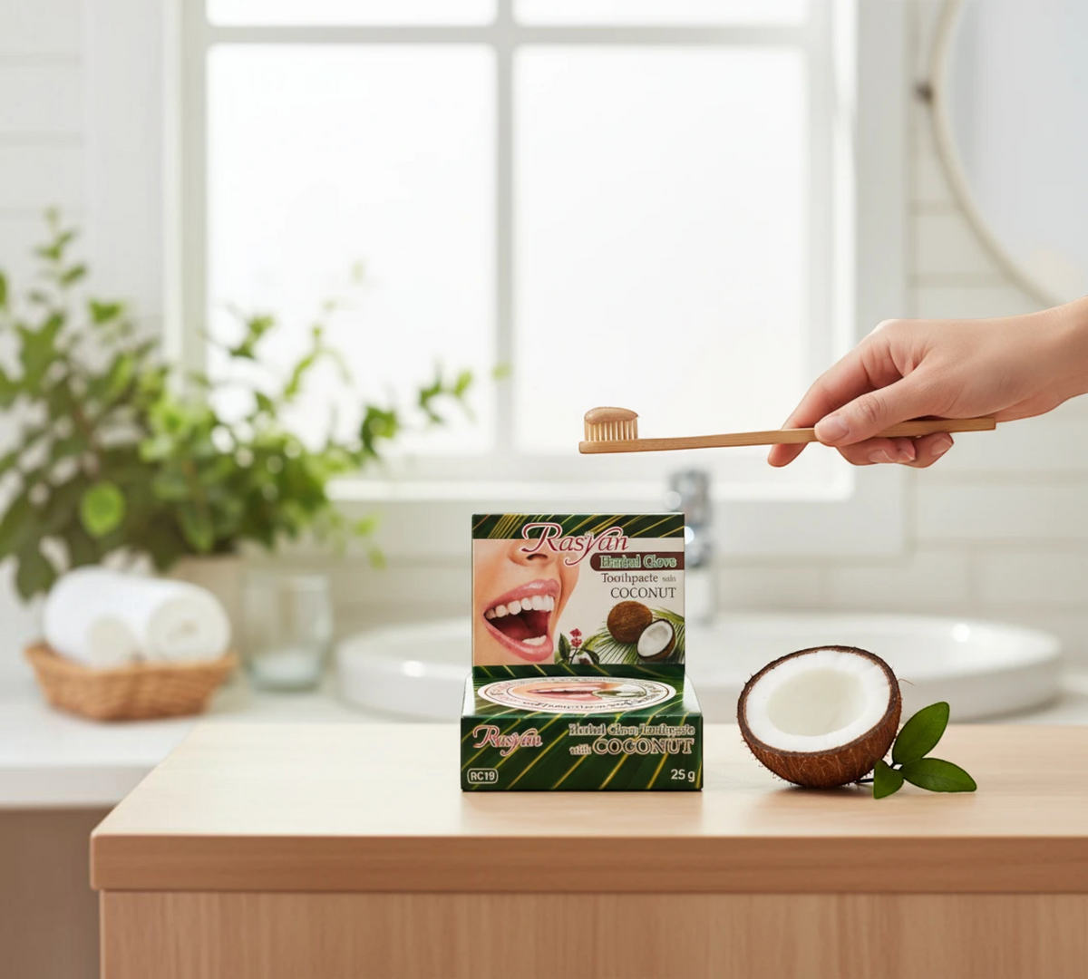 Thai Ranee Rasyan herbal clove and coconut toothpaste in a 25g box with a bamboo toothbrush and fresh coconut half