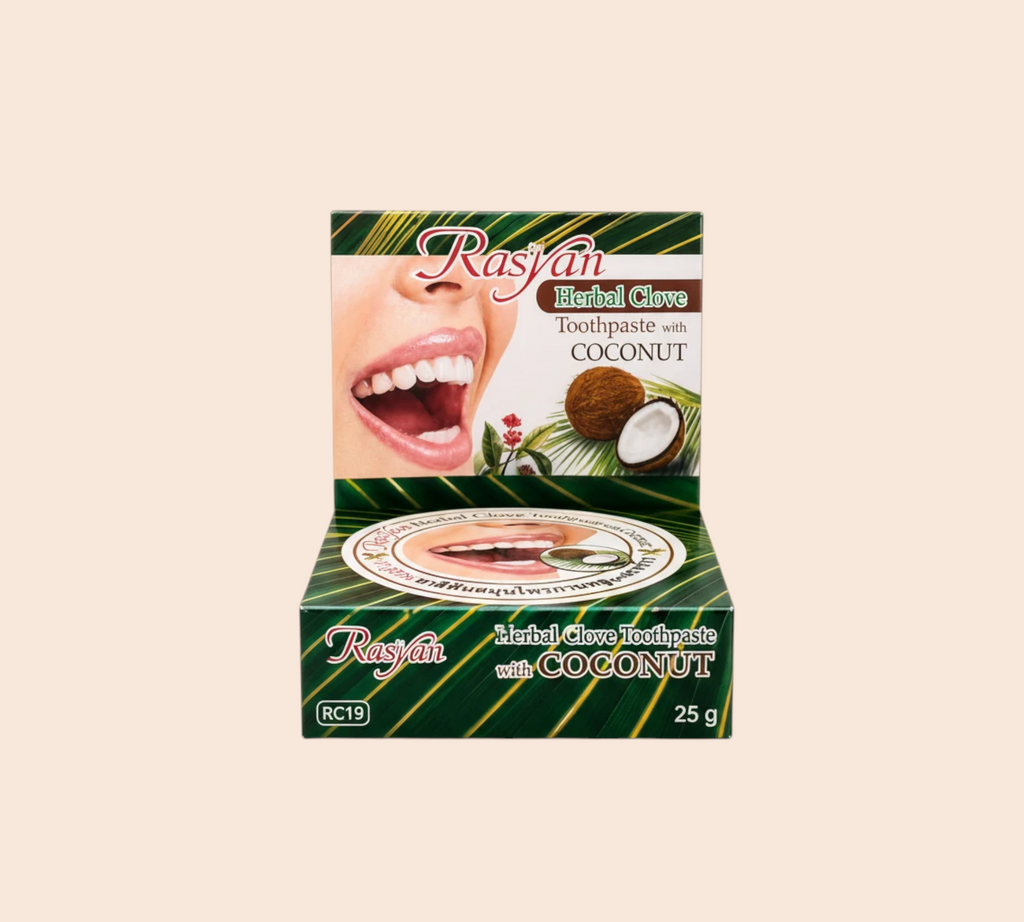 Thai Ranee Rasyan herbal clove and coconut toothpaste in a 25g box featuring a smiling mouth and coconut imagery.