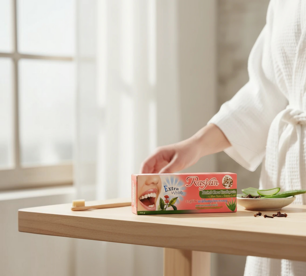 Thai Ranee Rasyan herbal clove toothpaste box with aloe vera and guava leaf on a wooden table with a toothbrush