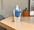 Thai Ranee Scentio Milk Plus Brightening Body Lotion with Co-Enzyme Q10 in a white and blue milk carton style bottle.